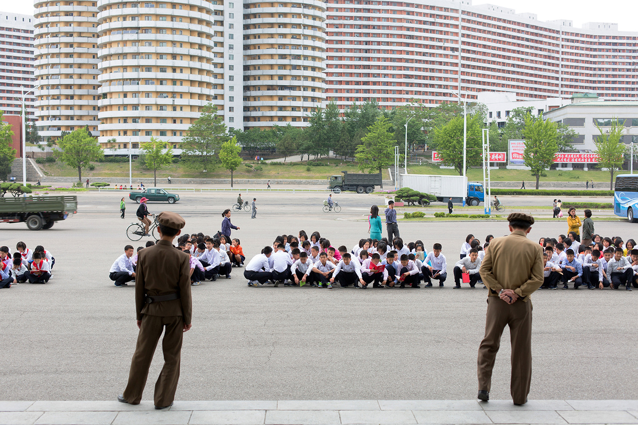 Diákok várakoznak a cirkusz előtti téren Phenjanban.