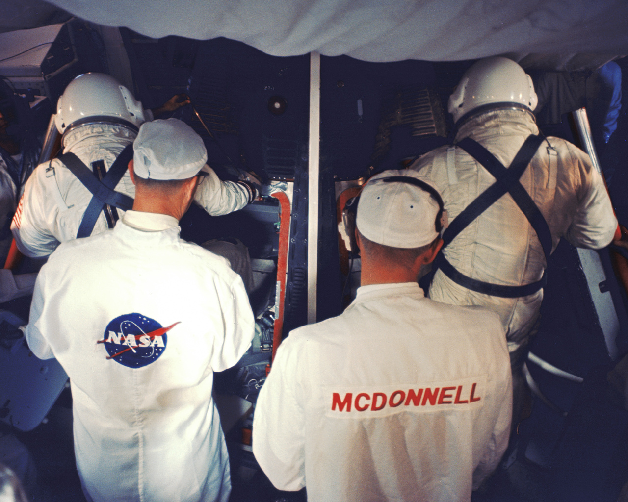 A NASA és a McDonnell technikusai segítenek a két űrhajósnak beszállni a Gemini-8 űrhajóba a start előtt a Kennedy Űrközpont 19-es startállásán. (35 mm-es diafilmkocka, 1966. március 16., NASA-azonosító: 104-KSC-66C-1852)