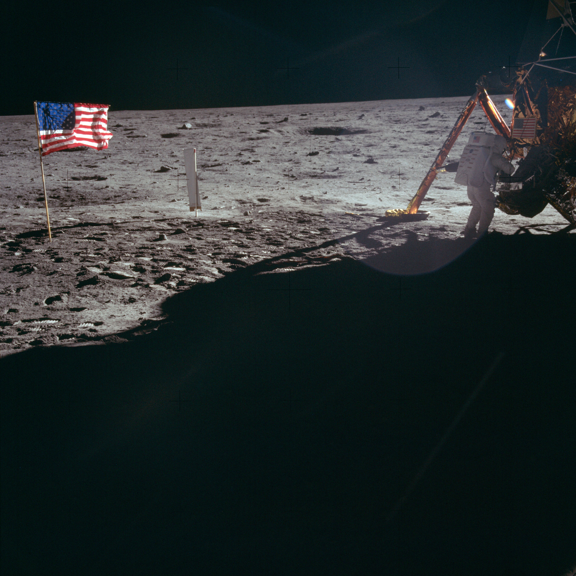 1969. július 20. Neil Armstrong a holdkompnál dolgozik. Ez az egyik olyan fotó, amin a Holdra elsőként lépő ember látható – háttal, távol a kamerától, ellenfényes becsillanástól kissé fakón. Fotó egy történelmi hősről, a történeti tetthez kissé méltatlanul, de személyiségétől annyira mégsem távol álló módon.