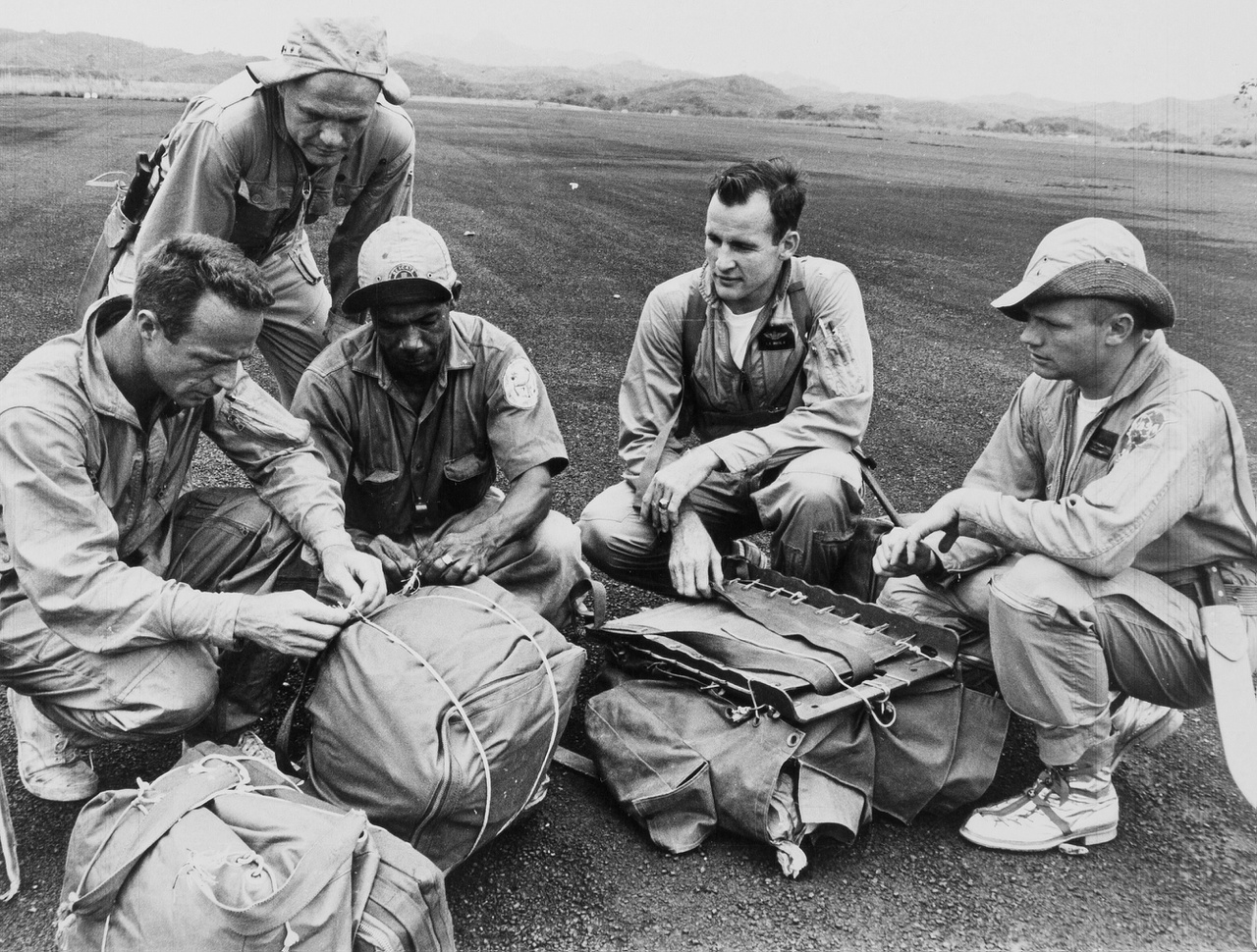 Balról jobbra: Scott Carpenter, John Glenn, Ed White és Neil Armstrong, valamint egy túlélőtábori instruktor csomagot kötöznek.