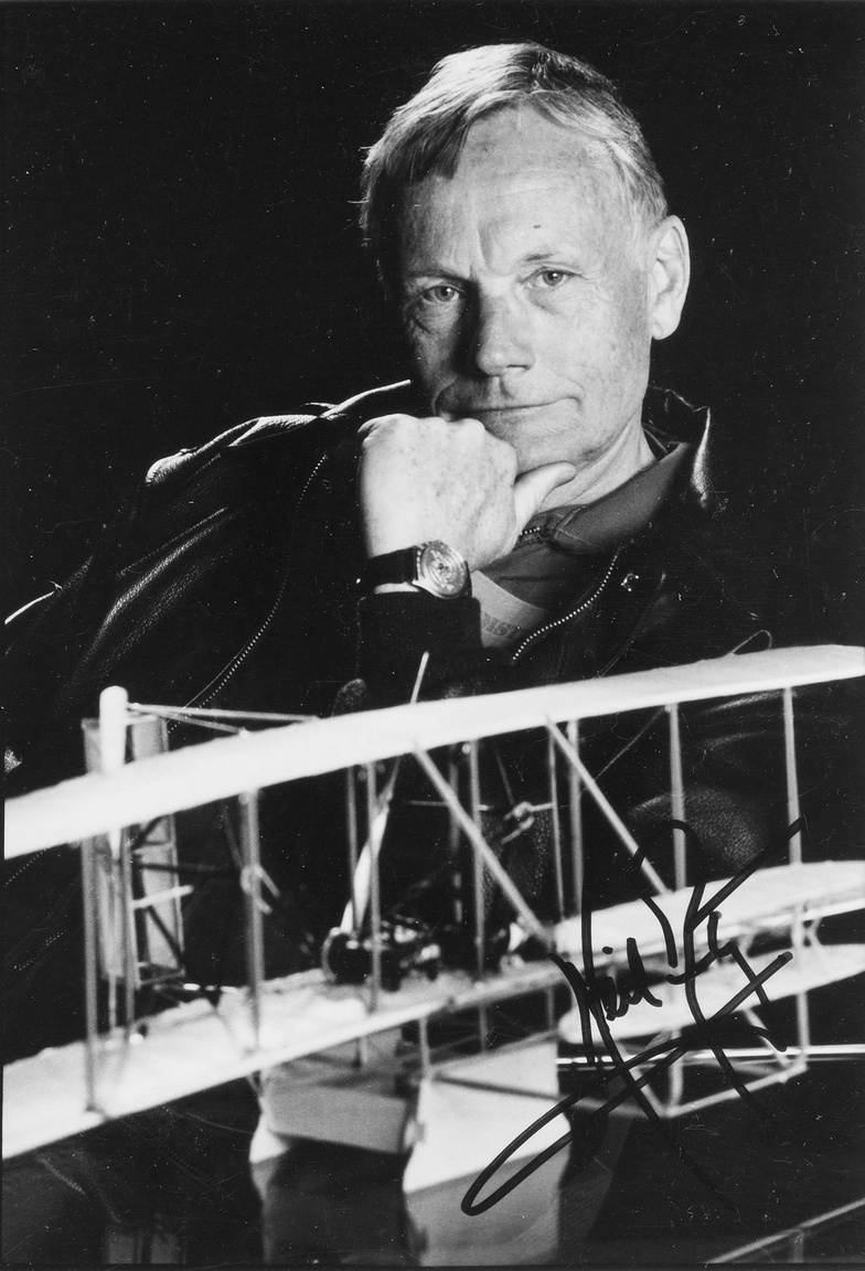 Egy ugyancsak ritka portré, családi célra készült, nem hivatalos NASA-fotó (Armstrong 1971-ben vonult vissza a NASA-tól, a civil életben egy sor amerikai cégnek lett a szóvivője, igazgatósági tagja). A nyolcvanas évekből származó dedikált képen Armstrong a Wright-testvérek első repülőgépének modelljével pózol