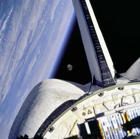 1998. november. Az STS-95-ös küldetésen - 25 repülésén - lévő Discovery, az Atlanti-óceán és a Hold. A fedélzeten ott van a NASA veterán űrhajóshőse, John h. Glenn is, akinek ez a második űrrepülése, miután 1962-ben a Friendship 7-tel első amerikaiként megkerülte a Földet. Glenn ezzel a repüléssel a legidősebb aktív űrhajós címet érdemelte ki. 
            