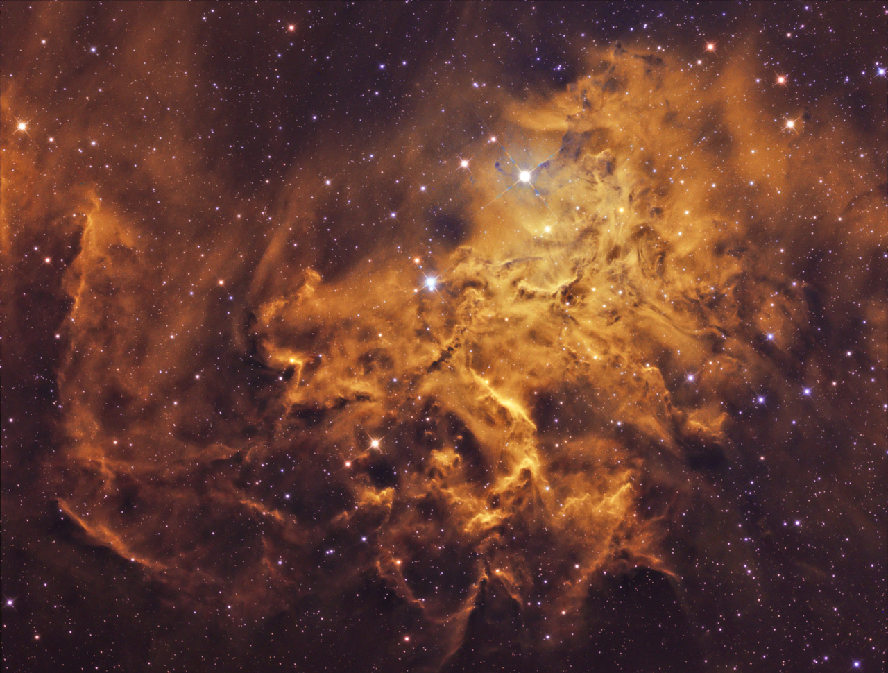 "Valami nagy-nagy tüzet kéne rakni." Ezen a fotón a Szekeres csillagkép szívében található diffúz köd, a Lángoló csillag-köd látható. Megjelenésében nagyon hasonlít a tűzhöz, lobogó lángnyelvekhez, innen a fantázia név. Ezt a látványt nagyban erősíti a HST, Hubble fotóknál is használt színpaletta, amelyet Bagi László kép elkészítésekor használt. A lángoló Csillag-köd Földünktől 1500 fényév távolságra található. A végleges fotó 28,5 óra expozíció eredménye.