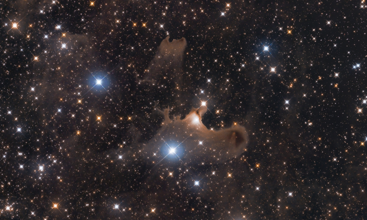 A Vdb141-Szellem-köd régió. Ha figyelmesen nézzük a kép középső területét, jól kivehető két szellem alak, ahogyan
                        kezüket az ég felé tartva integetnek. Ez a ködkomplexum a Cepheus csillagképben található, a főleg porból álló ködösség születés előtt álló, és éppen keletkező csillagoknak az otthona. Földtől való távolsága megközelítőleg 1470 fényév. Az ilyen ködösségek sajátossága, hogy rendkívül halványak, ezért nagy kihívás a megörökítésük. A végleges fotó 32 órányi expozíció eredménye, amelyet három hónap alatt, szeptembertől novemberig gyűjtött össze Bagi László.