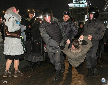 Orosz rendőrök letartóztatnak egy férfit, aki egy engedély nélküli tüntetésen vett részt a moszkvai Vörös tér közelében lévő bazársoron az oroszországi parlamenti választások napján.