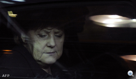 Angela Merkel arca az autó üvegén keresztül, amikor megérkezik egy informális munkavacsorára.