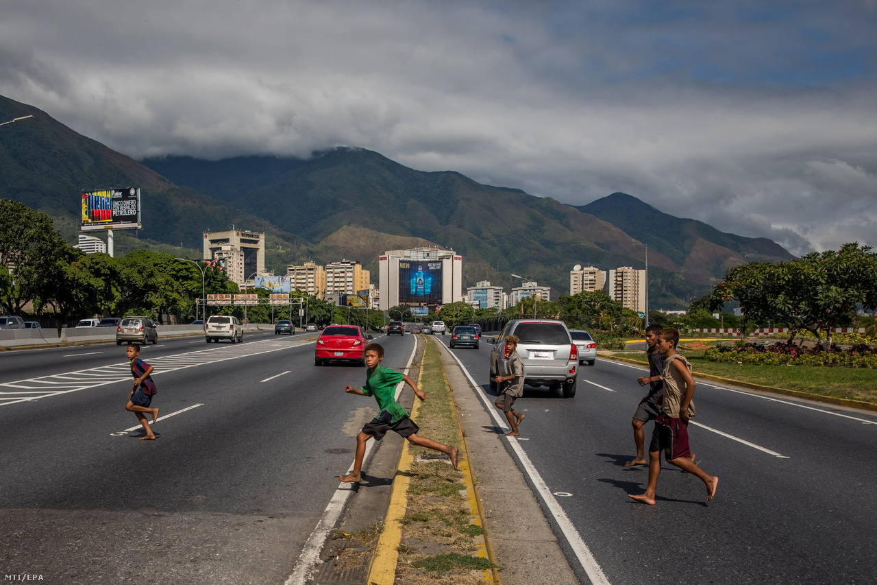 Utcagyerekek futnak át egy többsávos autóúton Caracasban, miután előkerestek egy zsák ruhát, amit még korábban rejtettek el.
                        Sokakat az éhség hajtott, mások családi problémák elől menekültek, és látszólag nem mindig függ össze sorsuk az országban kialakult válsággal. A legtöbben mégis azután kerültek sokszor vidékről Caracas utcáira, hogy 2014-ben beszakadt az olajár, és magával rántotta a szociális juttatások hálója, és az egysíkú export miatt egy lábon álló chávezista rendszert.