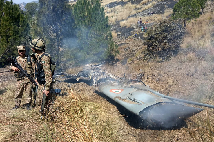 Pakisztáni katonák a lelőtt indiai harci repülőgép roncsánál, a Pakisztán által ellenőrzés alatt tartott Kasmír területén 2019. február 27-én