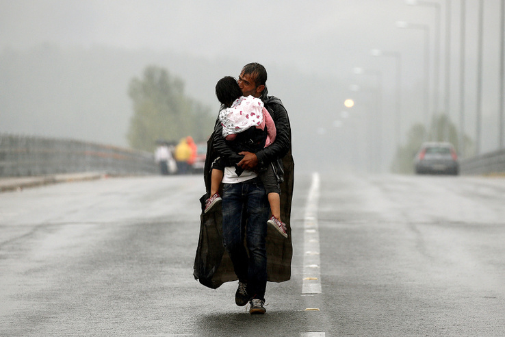 Egy szíriai menekült és kislánya a szakadó esőben a görög-macedón határnál 2015. szeptember 10-én.