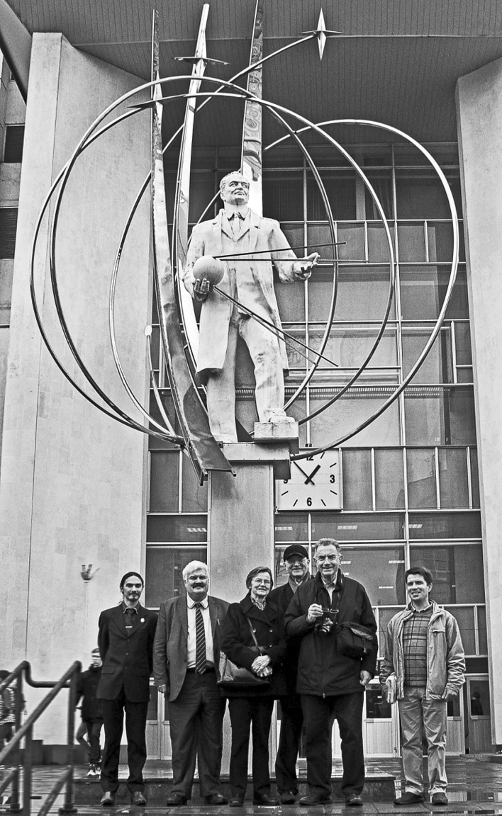 A könyv szerzői Szergej Koroljov rakétamérnök, a szovjet űrprogram atyjának szobra előtt. (Balról a harmadik: Hargittai Magdolna, fényképezőgéppel a nyakában Hargittai István.) Koroljov kezében az első műhold, a Szputnyik modellje, alakját orbitális pályákra emlékeztető körök, ívek veszik körül.