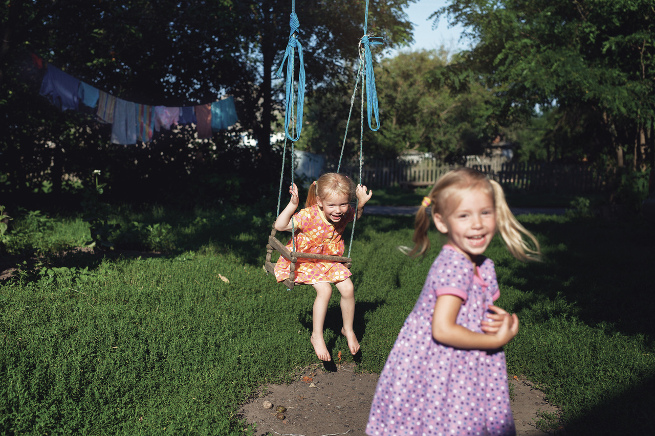 Mezítlábas kislányok játszanak egy ukrajnai falu egyik udvarán.