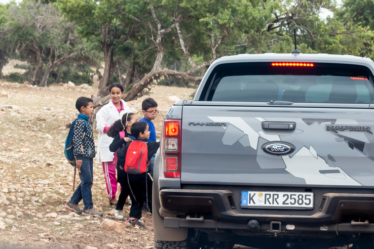 Nagyon Afrika: gyerekek csodálkoznak rá az új pickupokra. A háttérben zöldellnek az argánfák