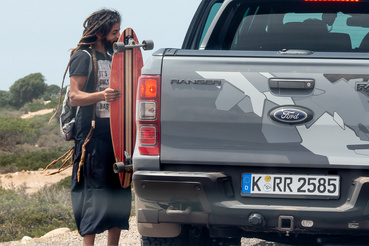 Bestoppolt a konvojba egy helyi raszta. A srác turistáknak árul karkötőket Szavírában és ehhez húsz kilométert longboardozik oda-vissza az üres utakon 