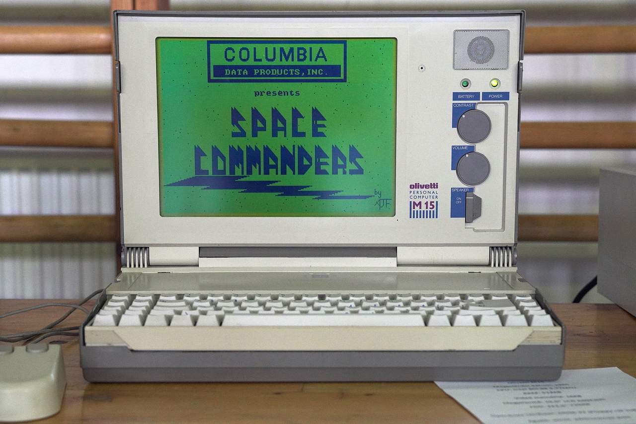 Az egyik legszebb laptop a kiállításon, egy 1985-ös Olivetti M15. 4,77 MHz-es Intel 80C88 processzor ketyeg benne, 512 kB RAM, 16 kB videómemóriája van, DOS 6.22-es oprendszer fut rajta (floppyról indítva), a kijelzője pedig kétszínű 10,5 inches, 620*200 pixeles felbontású LCD. 1987-ben kétezer dollárba került egy ilyen. Csak úgy hasít rajta a Space Commanders.