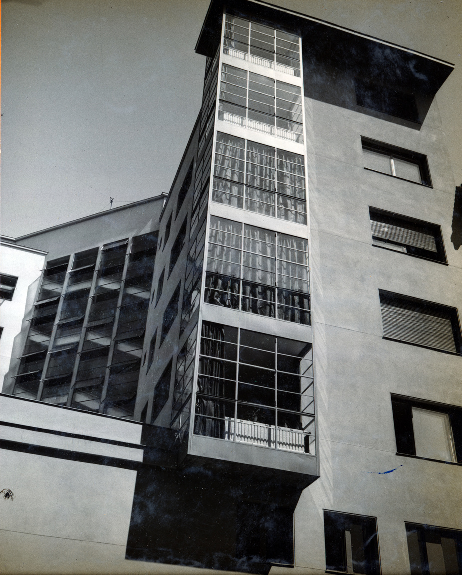 A homlokzaton végighúzódó üvegsávok mögött a felületes szemlélő talán lépcsőházat sejt. Sok helyen valóban ez volt a bevett szokás (a dessaui Bauhausnak is ilyen a lépcsőháza), de itt egy zárterkélysorról van szó. Ez volt az igazi dísze az épületnek a hegyesszögű sarkon is. Az üvegfalak mögött látszanak a függyönyök és a radiátorok, a kép baloldalán pedig ott az igazi lépcső.