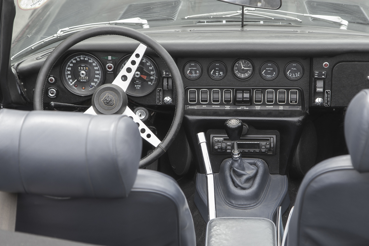 Amennyire lélegzetelállítóan gyönyörű a Jaguar E Type gúnyája, annyira egyszerű és célra törő a belseje. Éles a kontraszt a művészi vonalak és a meglehetősen ingerszegény, fekete belső között. Ettől még persze kéne, mocskosul, a gagyi rádió nélkül