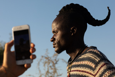 Mobiltelefon és törzs dísz: érdekes fotókon a mai világ kettőssége