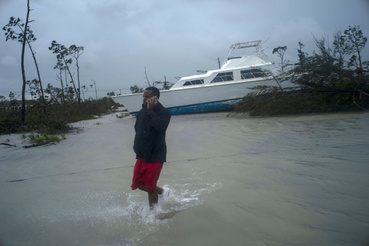 Férfi telefonál egy partra vetett hajóval a háttérben a Dorian hurrikán által elpuszított területen a Bahama-szigeten fekvő Freeportban kedden.