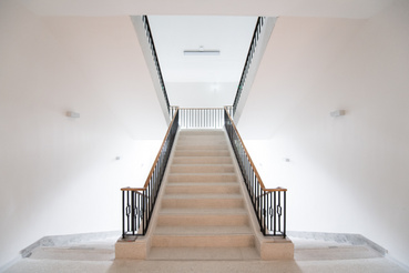 Helyreállított szocreál lépcsőház a MOME Masterben. A felfelé haladó lépcső új: stílusában követi az eredetit, de a korlátja egyszerűbb lett 