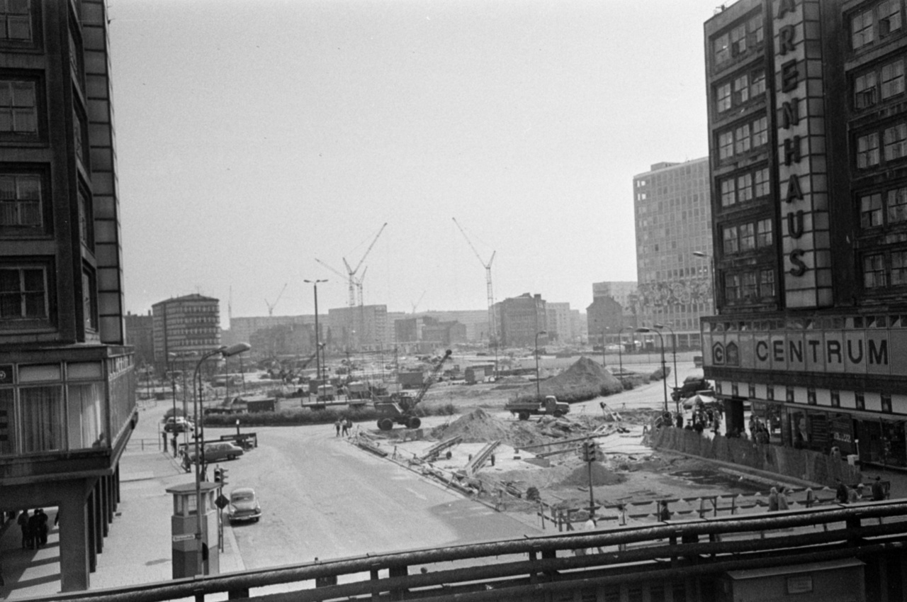 As construction of Berlin's TV tower began, the centre of East-Berlin was completely transformed: the historic buildings of Alexanderplatz were all demolished except for the Marienkirche and the Rotes Rathaus. The grey, cubical houses erected in their stead turned the area into a real phalanstery, although the cubical building seen in the front of the picture above still stands out despite its angular shape: it is Berolinahaus, a classic product of 1930s modernism.