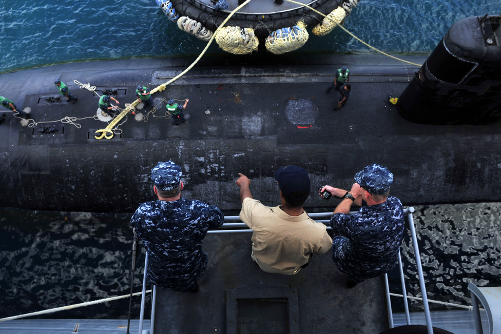 A Los Angeles-osztályú USS Tucson támadó tengeralattjáró kikötését figyelik a USS Emory S. Land tengeralattjáró-támogató hajó fedélzetéről.