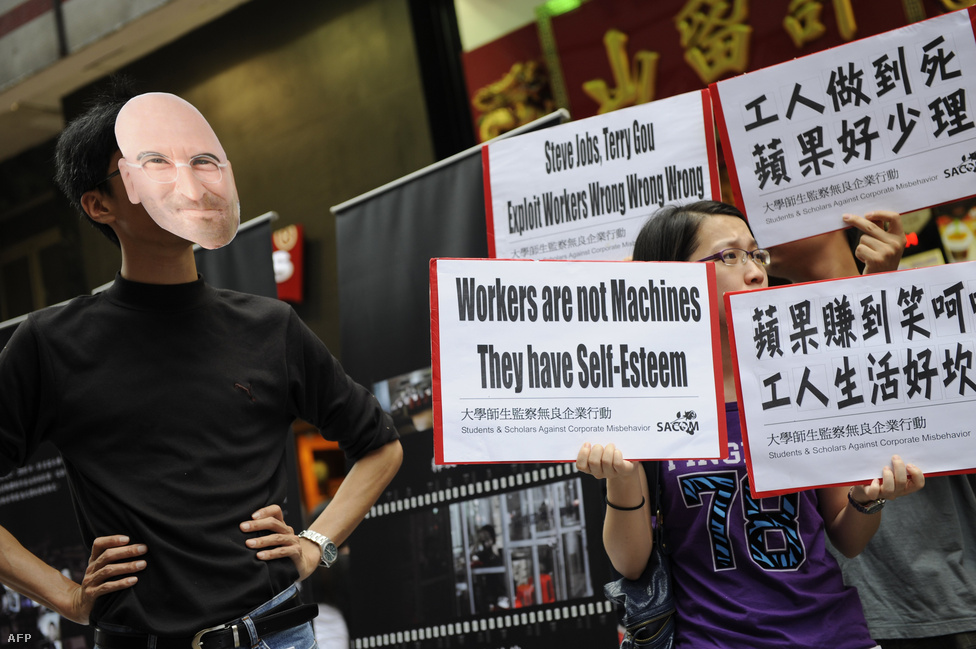 Az Iphone-ok a Foxconn nevű tajvan cég gyáraiban készülnek. A Foxconn dolgozói körében gyakori az öngyilkosság, amit a lelketlen munkakörülmény, a rabszolgasorhoz hasonlító munkakörülmények rovására írnak. A képen egy Hong Kong-i tüntetés résztvevői demonstrálnak az Apple és a Foxconn ellen 2011. május 7-én.