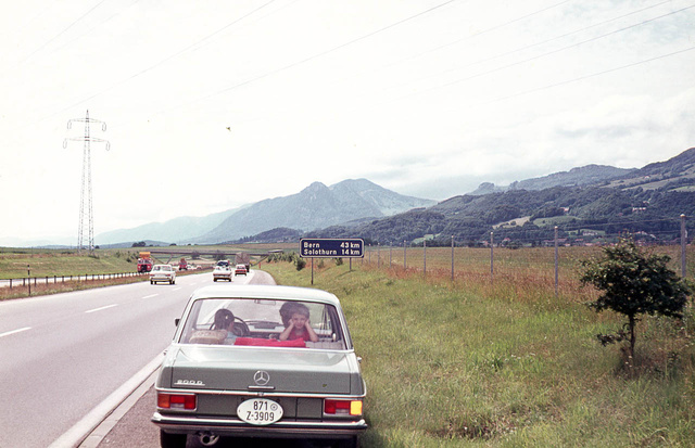 1972, az autó már egy napja megvan, megyünk Bern felé. Én piros pólóban a hátsó ülésen. Figyeljék a piros törölközőt a kalaptartón, a jobbra kitett indexet és a régi fajta, ovális, német zollrendszámot