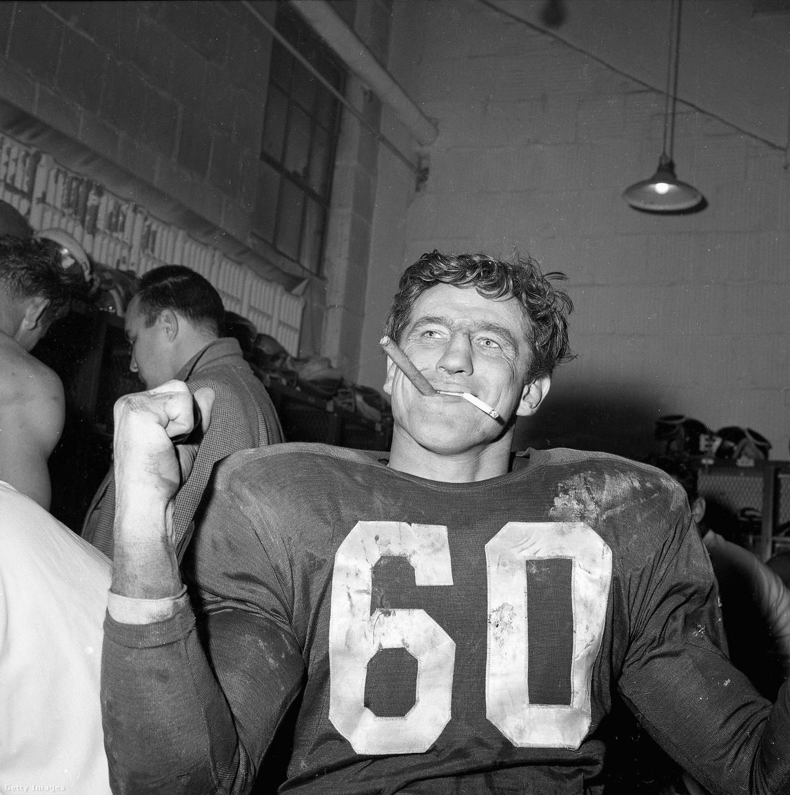Talán többen ismerik a képet, amin Len Dawson az első Super Bowl szünetében cigizget, de kevés kép mutatja jobban, mennyire más volt a világ az 1960-as évek elején, mint most, nagyjából 60 évvel később: Chuck Bednarik, a Philadelphia Eagles centere egy szivarral ÉS egy cigarettával a szájában ünnepli az Eagles 1960-as, a Green Bay Packers ellen nyert bajnoki címét. A mérkőzés jelentősége nem elhanyagolható, Vince Lombardi pályafutása során először és utoljára kapott ki a rájátszásban edzőként. A szlovák származású, de már Amerikában született Bednarik az 1950-es évek, illetve az NFL 75 és 100 éves álomcsapatába is bekerült, 60-as mezét visszavonultatta az Eagles, illetve az egyetemi bajnokságban és az NFL-ben is halhatatlan lett. Egyetemi játékosként szinte minden meccset végigjátszott a támadó- és védőcsapatban egyszerre szerepelve, utóbbinak állít emléket, hogy róla nevezték el az év legjobb egyetemi védőjátékosának járó Chuck Bednarik-díjat. Az, hogy az amerikaifutballban csúcsra ért, különös megkoronázása volt annak, hogy a második világháborúból hősként, 30 sikeres repülős küldetés után tért vissza. A 60-as évek viszont csak a megbecsülésről szóltak, Bednariknak az amerikaifutball-szezonon kívül betont kellett árulnia, hogy megéljen, innen, és nem az egyébként kivételes keménységéből jött a "Beton Charlie" becenév.
                        