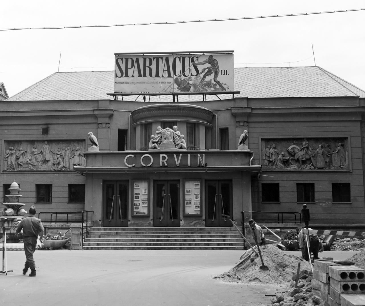 Kirk Douglas legendás filmjét, a Spartacust csak 1970-ben tűzte műsorra a Corvin mozi. Az épület még jóval kisebb volt, mint mai valójában, a kilencvenes években történt felújítása után. A tizenöt évvel korábbi fegyveres harc nyomai nem látszanak a fényképen, de tudjuk, hogy az egykori sarokház helyére már új épület került. A munkálatok csatornázásra utalnak, de a mozi töretlenül működik, és tetején a két részes színes – panoráma – szélesvásznú amerikai filmet, a Spartacust (R. Stanley Kubrick, 1960) hirdetik óriási betűkkel és egy rajzolt gladiátorjelenettel.