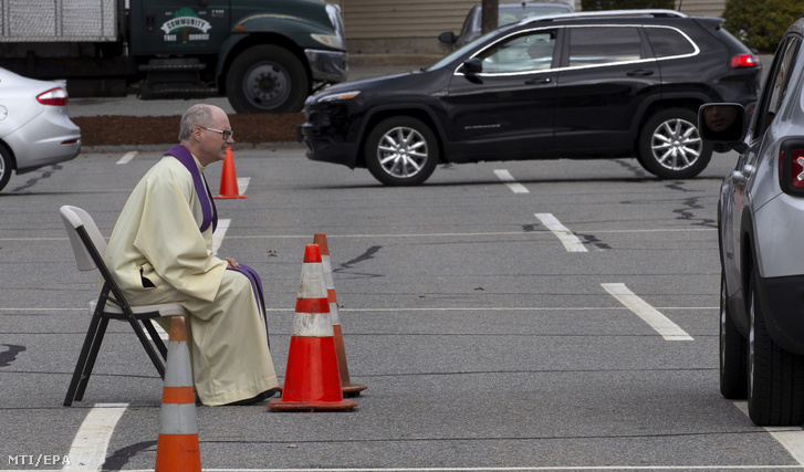 Brian Mahoney katolikus pap az egyik autóban ülõ hívõ gyónását hallgatja a koronavírus-járvány miatt bezárt Szent Mária-templom parkolójában a Massachusetts állambeli Chelmsfordban 2020. április 1-jén. A hívõknek szerdánként 16 óra és 18 óra között biztosítanak lehetõséget a gyónásra.
                         