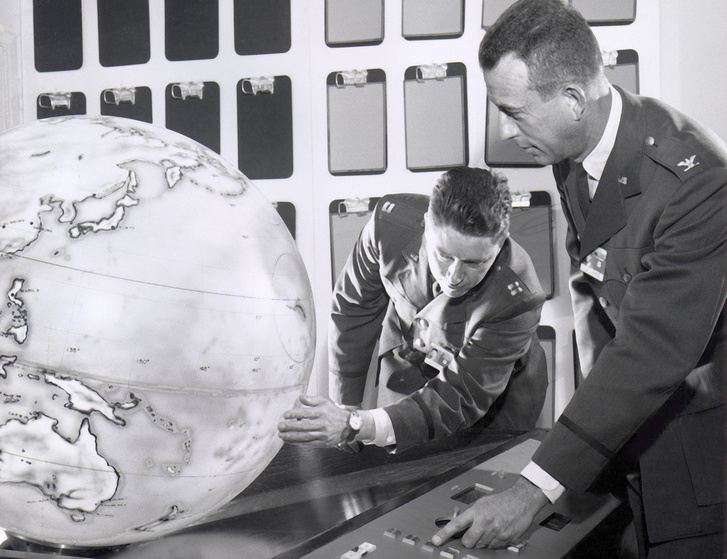 1961: Lee Battle ezredes, a Discoverer program igazgatója és William Johnson százados az egyik kémműhold pályáját tanulmányozzák egy elektronikusan vezérelhető, belső kivetítéses földgömbön.