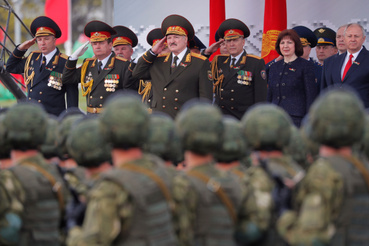 Alekszender Lukasenka (középen) tiszteleg a katonai parádén