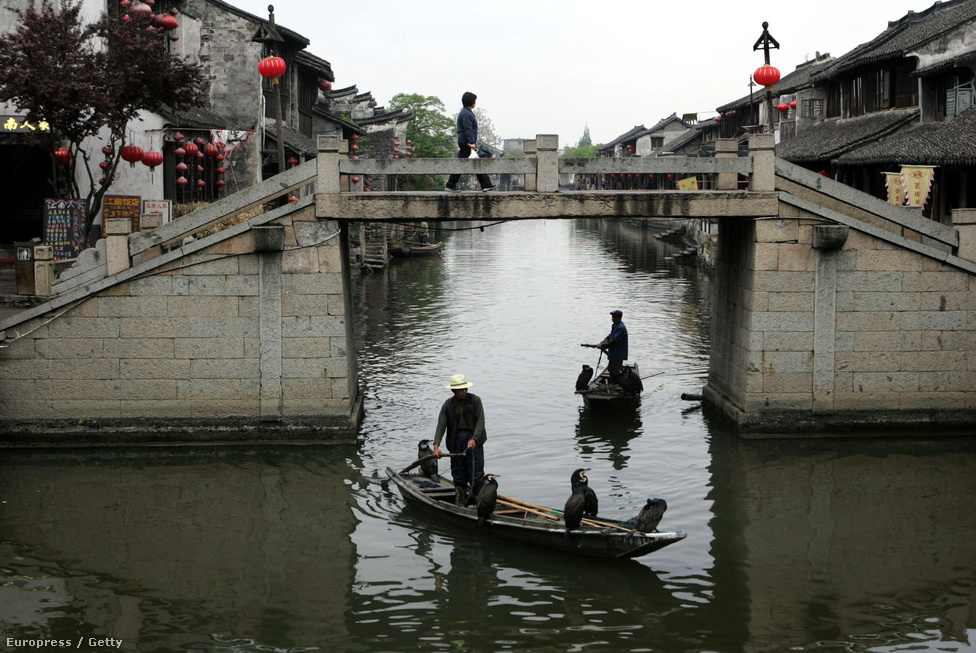 Halászok és madarak csónakáznak a Kína Velencéjének tartott  Hsziatang (Xiatang) városban, ahol 104 hídon közlekednek a lakók a vízi utcák felett.
                        