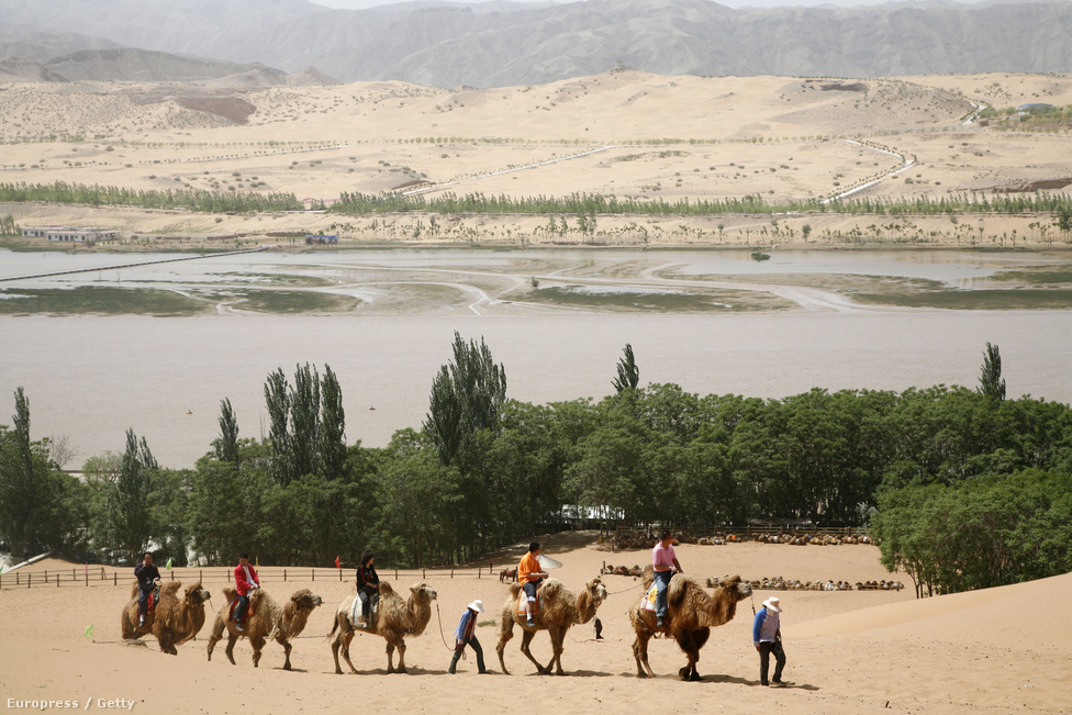 Tevés turistacsoport a Sárga-folyó partján. Ninghszia (Ningxia) autonóm tartomány lakosságának négy százaléka él a folyó közelében, de a mezőgazdasági termelés miatt a folyó vízmennyiségének 18 százalékát felhasználják öntözésre.