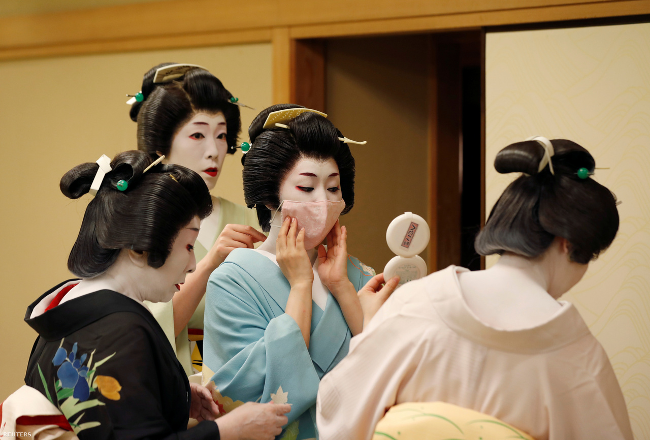 Szenior gésák segítenek feltenni a védőmaszkot Koikunak