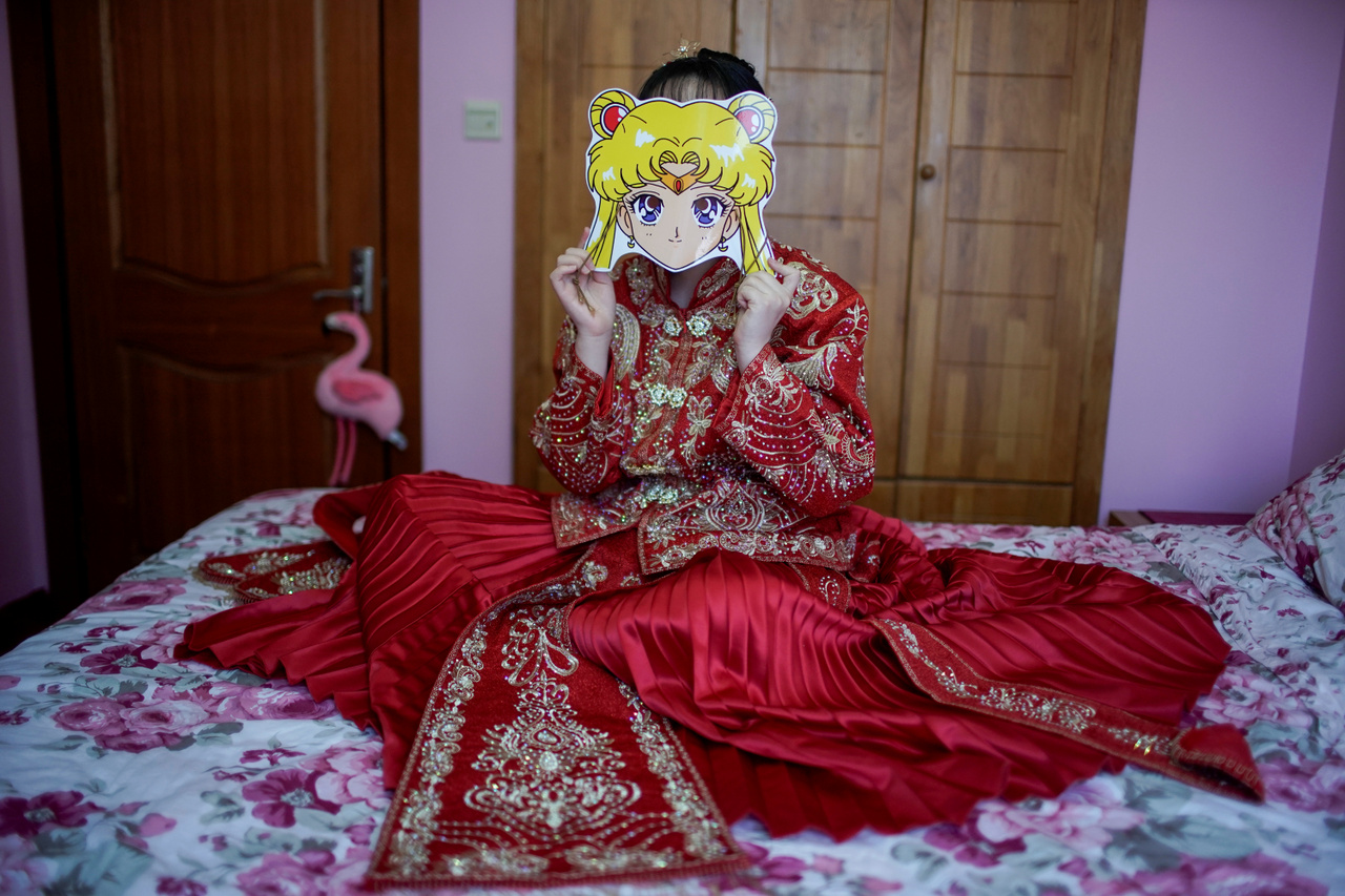 Vej Csiaven egy Sailor Moon maszkot tesz az arca elé az esküvői fotózáshoz.