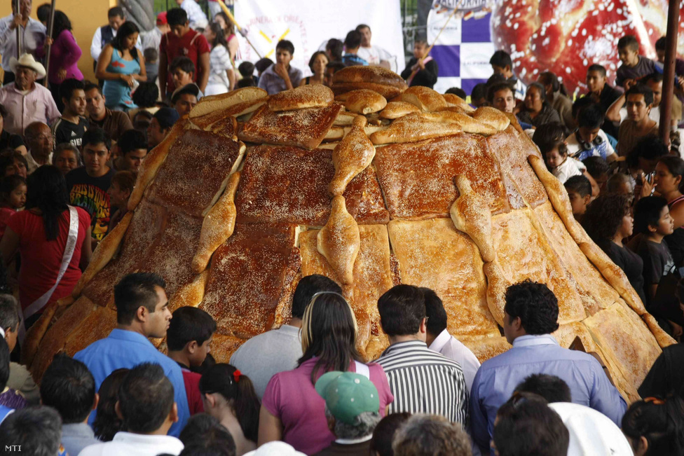 Érdeklődők nézik Mexikó legnagyobb leveles tésztából készített úgynevezett halotti kenyerét a Puebla megyében fekvo Cuauhtlancingóban. A hagyományosan a halottak napja alkalmából sütött étel különleges méretu kivitele 330 cm átméroju 172 cm magas és 14 tonna súlyú.