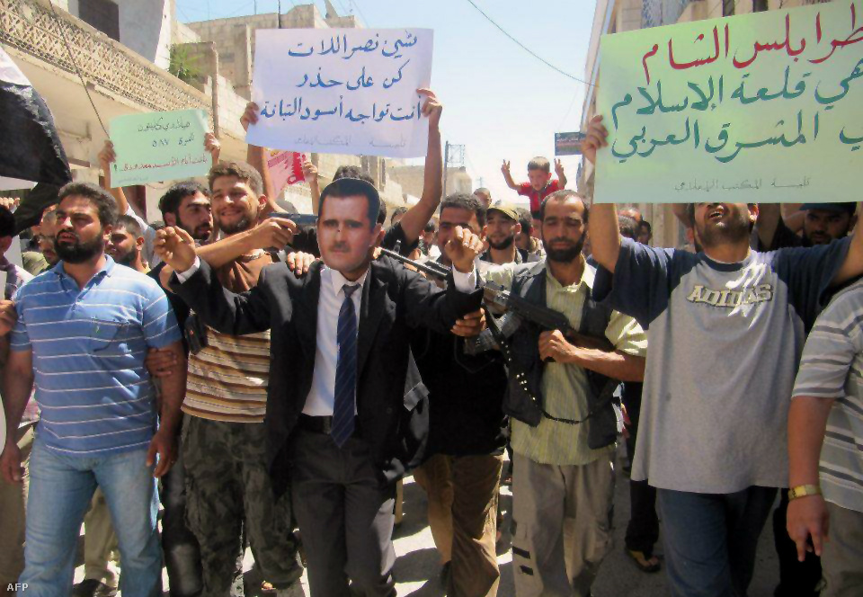 Aszad elnök képmását viselő férfi demonstrál a felkelőkkel Homszban. A felkelők hírügynökségének felvétele.