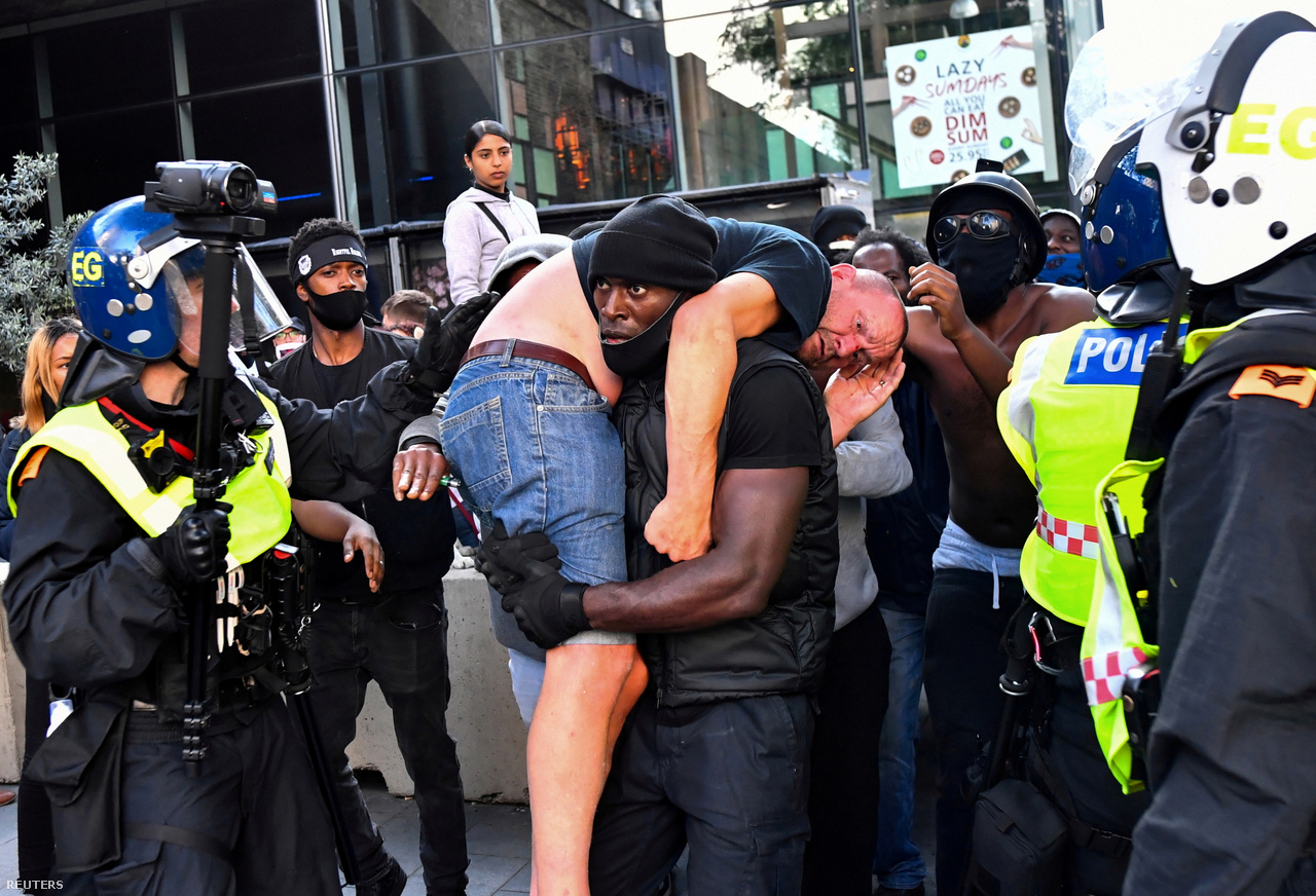 Patrick Hutchinson tüntető egy sérült ellentüntetőt visz biztonságos helyre a Black Lives Matter tüntetésen Londonban, 2020. június 13-án.