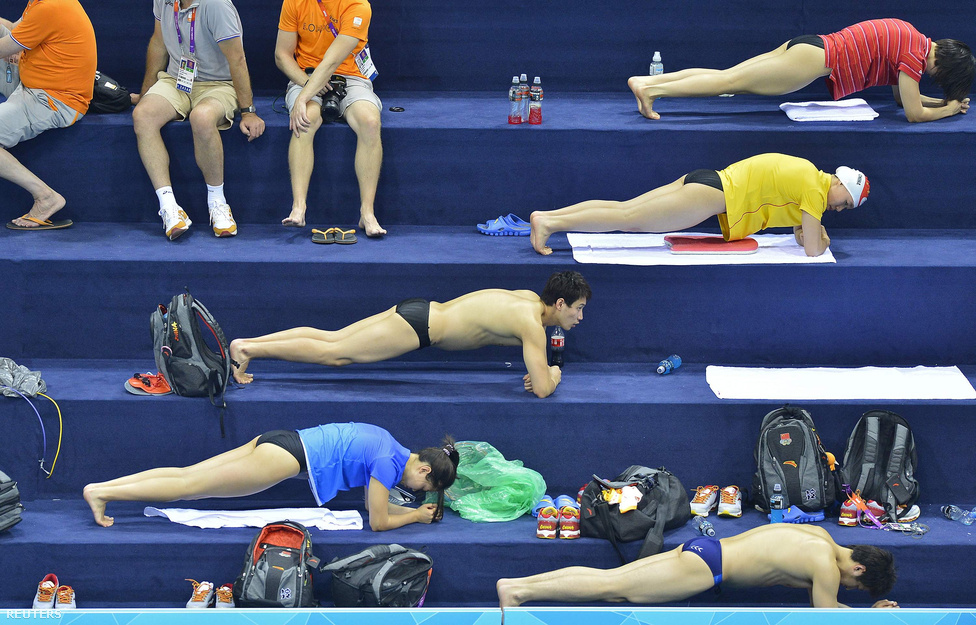 Kínai úszók törzserősítő gyakorlatokat végeznek a londoni Aquatics Centreben, röviddel az olimpiai úszószámok kezdete előtt július 24-én. 
