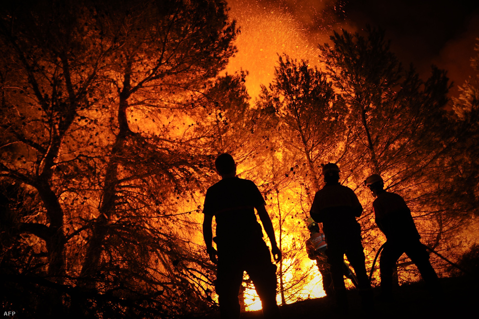 Tűzoltók próbálják megfékezni a lángokat a spanyol Macane hegyen, Alicante város közelében augusztus 13-án. 