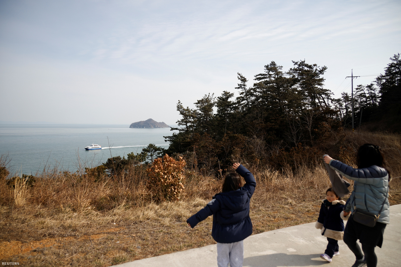 A hét éves Lyoo Chae-hee integet a Dél-Korea szárazföldjére visszainduló komp után. Nok-sziget, 2021. február 26-a.