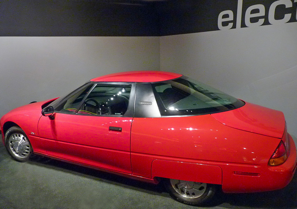 Az 1966-ban piacra dobott EV1 a General Motors első modern elektromos hajtású autója volt, és alaposan megelőzte korát. Nem valamely korábbi benzines típus átalakításával készítették el, hanem az alapoktól villanyautónak tervezték. Csak Kaliforniában és Arizonában lízingelték és szervizelték. Bár a tulajdonosok szerették, a GM nem fejlesztette tovább, sőt, a lízinget felmondta, az autókat visszagyűjtötte és megsemmisítette. A döntésre máig nincs hiteles magyarázat, állítólag az olajlobbi nyomása kényszerítette ki.   