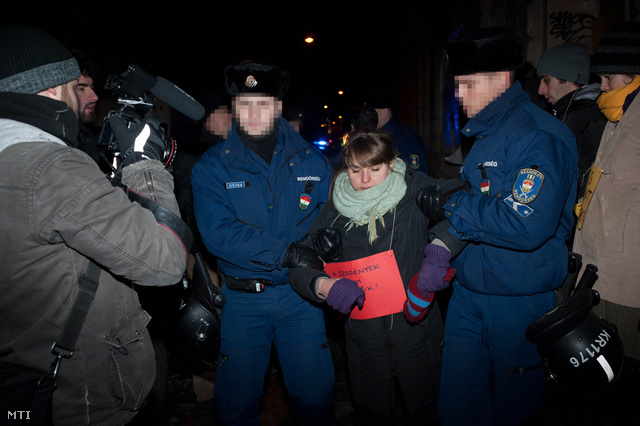  Rendőrök visznek el egy aktivistát egy üresen álló lakóház elől a VII. kerületi Csányi utcában 2013. január 19-én, miután a Város Mindenkié csoport demonstrációján civil és hajléktalan aktivisták foglalták el az önkormányzati tulajdonban lévő kétszintes épületet.