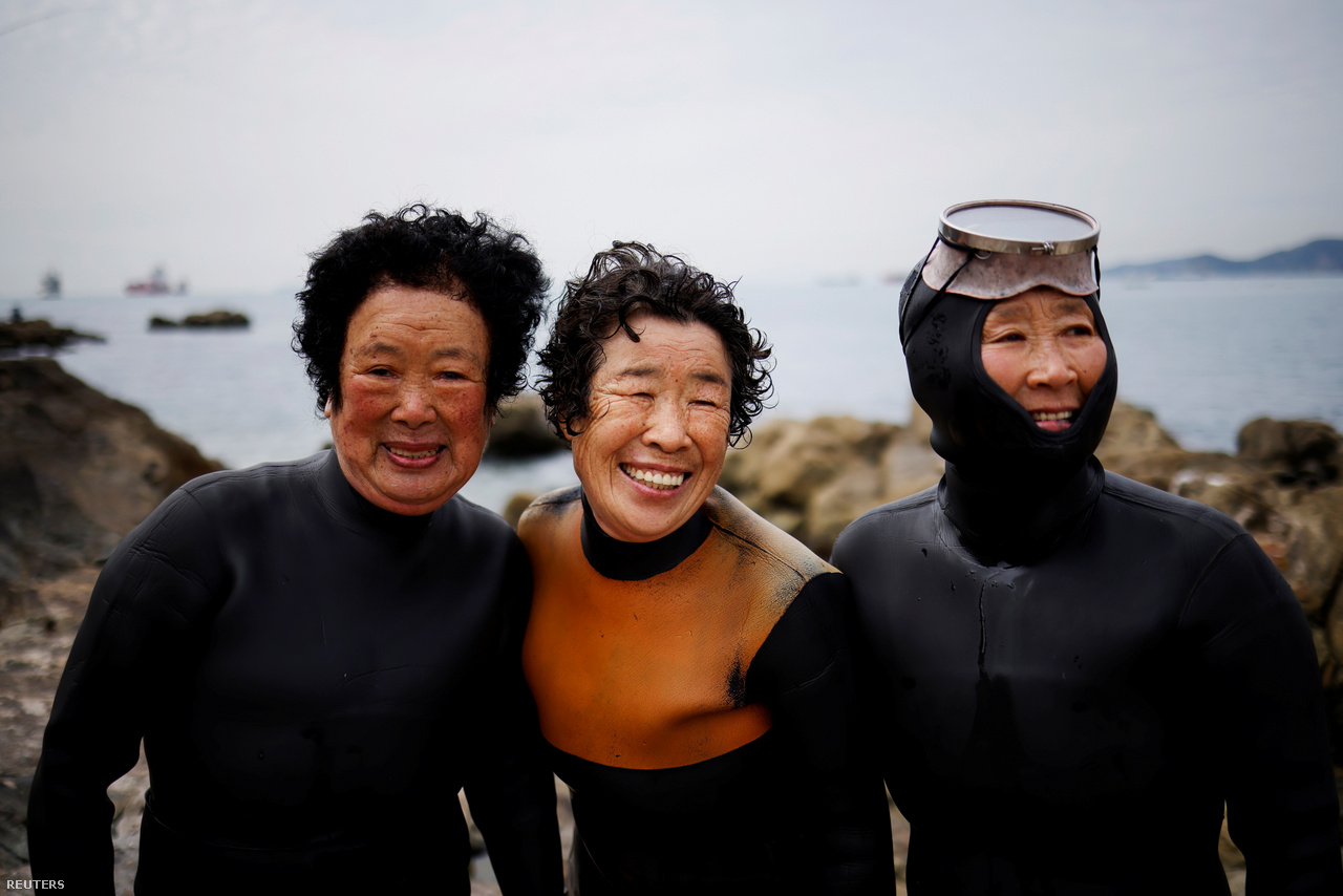 Három idős henyo, a 84 éves Dzsung Szunja, a 74 éves Ko Kumszun és a 69 éves Jun Jonok mosolyognak a fényképezőgép lencséjébe Puszan mellett 2021. április 6-án.