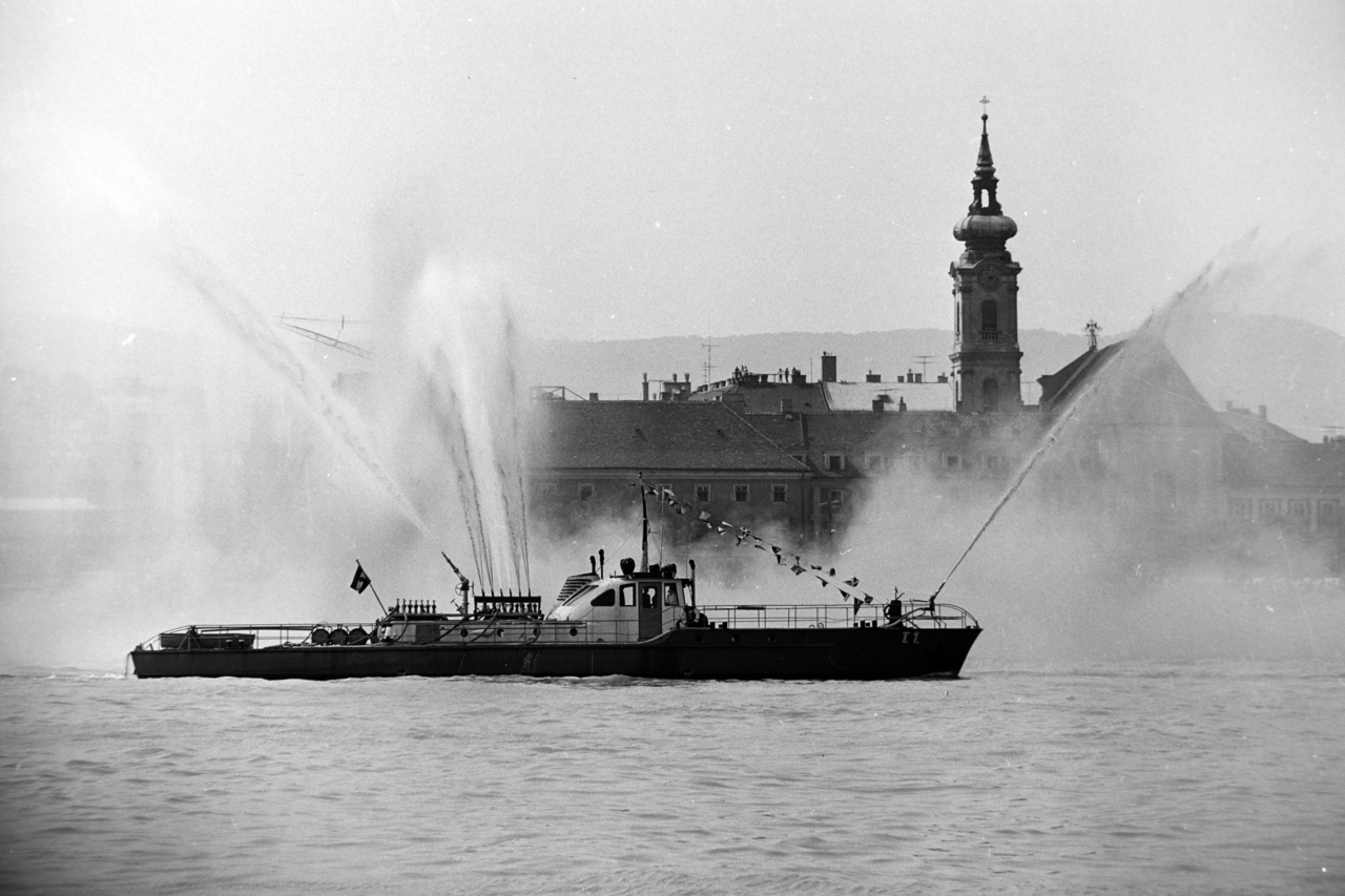 Tűzoltóhajó az augusztus 20-i légiparádén, 1970.A tűzoltóhajók békeidőben a parádé részét képezik, de eredeti hivatásuk a szárazföldről nem megközelíthető vagy vízen – ilyen például a hajókon keletkezett tüzek oltása. Az első szivattyúhajókat, Gigant és Pluto névre keresztelték, az Osztrák-Magyar Monarchia Császári és Királyi Haditengerészet részére gyártották le 1877-1878-ban, és feltehetően ezek voltak az első tűzoltóhajók is egyben. A legelső hazai gyártmány a Szent Flórián néven Angyalföldön vízre bocsátott hajó, melynek feladata a tűzoltás és műszaki védelem volt. 1947-ben Vörös Október névre keresztelték át, és 1961-ig ezen a néven teljesített szolgálatot. A képen látható jármű a T1 tűzoltóhajó, ’61-ben vette át a szolgálatot a Vörös Októbertől. 1982-ig tartó szolgálata alatt változatos feladatokat látott el öt fős tűzoltó személyzetével. Hajótüzek, partmenti tüzesetek mellett árvizeknél is bevetették. Jelenleg szolgáló tűzoltóhajó Magyarországon a Szent Flórián nevet kapta; a 13 méter hosszú