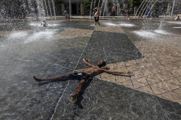 Egy férfi a városháza előtti szökőkutak vízében hűti le magát a hőségben a kanadai Edmontonban 2021. június 30-án