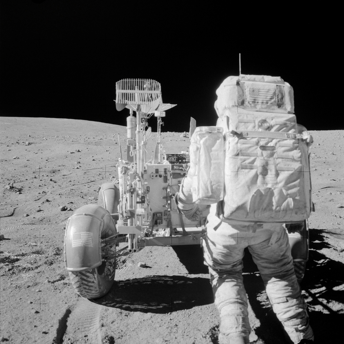 John W. Young éppen eszközöket pakol a holdjáró kéziszerszámtartójába az Apollo-16 misszió második űrsétáján. Eredetileg az Apollo-16-on akarták volna először használni a holdjárót, de a program újratervezése végett az Apollo-15 asztronautái autóztak először az űrben. Az Apollo-16 holdjárójával gondok voltak, az összehajtogatott kerekek nem álltak automatikusan pozícióba és a hátsó kerekek kormányzása sem akart működni.
                        