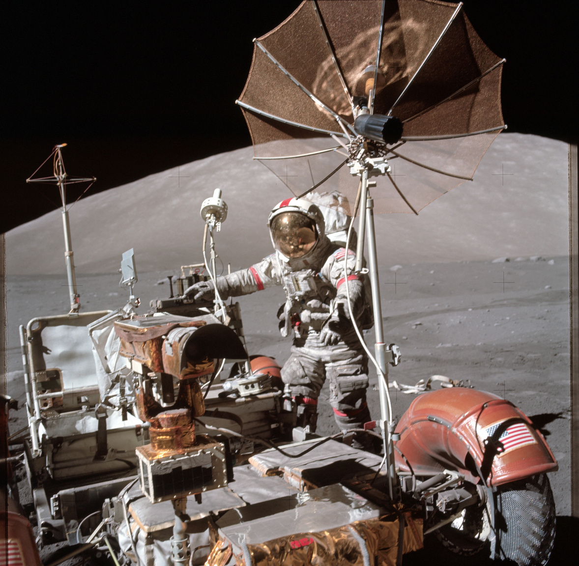 Az Apollo-17 parancsnoka, Eugene Cernan a leparkolt holdjáró mellett. A képet több helyen is érdemes tüzetesebben megnézni. A bal sarokban látszik, ahogy a hátsó kerék sárvédője megtört és térképeket odaragasztva küszöbölték ki a csorbát az űrhajósok. Cernan ruhája valamennyire beszürkült a Hold felszínéről ráragadt portól, többek között ezért is volt fontos része a holdjárónak sárhányó: a fehér ruhára rakódó sötét por rontotta a hőálló képességeit a szkafandernek, ezzel veszélyeztetve az asztronauták életét. A harmadik érdekesség ami jól megfigyelhető a képen, az a titánhálóból készült kerék.
                        