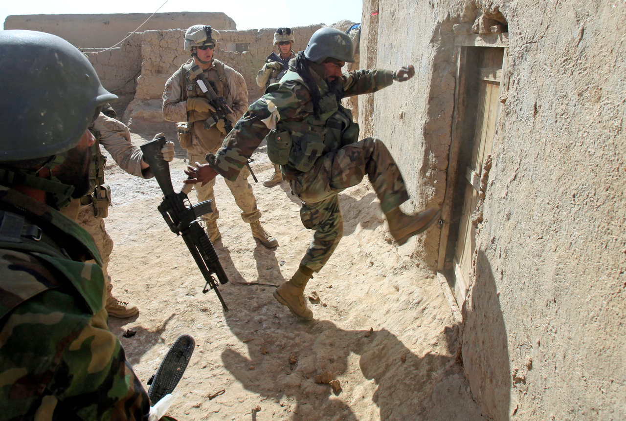 Amerikai tengerészgyalogos rúgja be egy vidéki ház bejáratát Helmand tartományban. Az egyik legnagyobb NATO-műveletnek már első napján komoly ellenállásba ütköztek ai katonák, a tálibok mesterlövészekkel, robbanószerkezetekkel várták őket.
                        Marjah, 2020. február 17-e. 